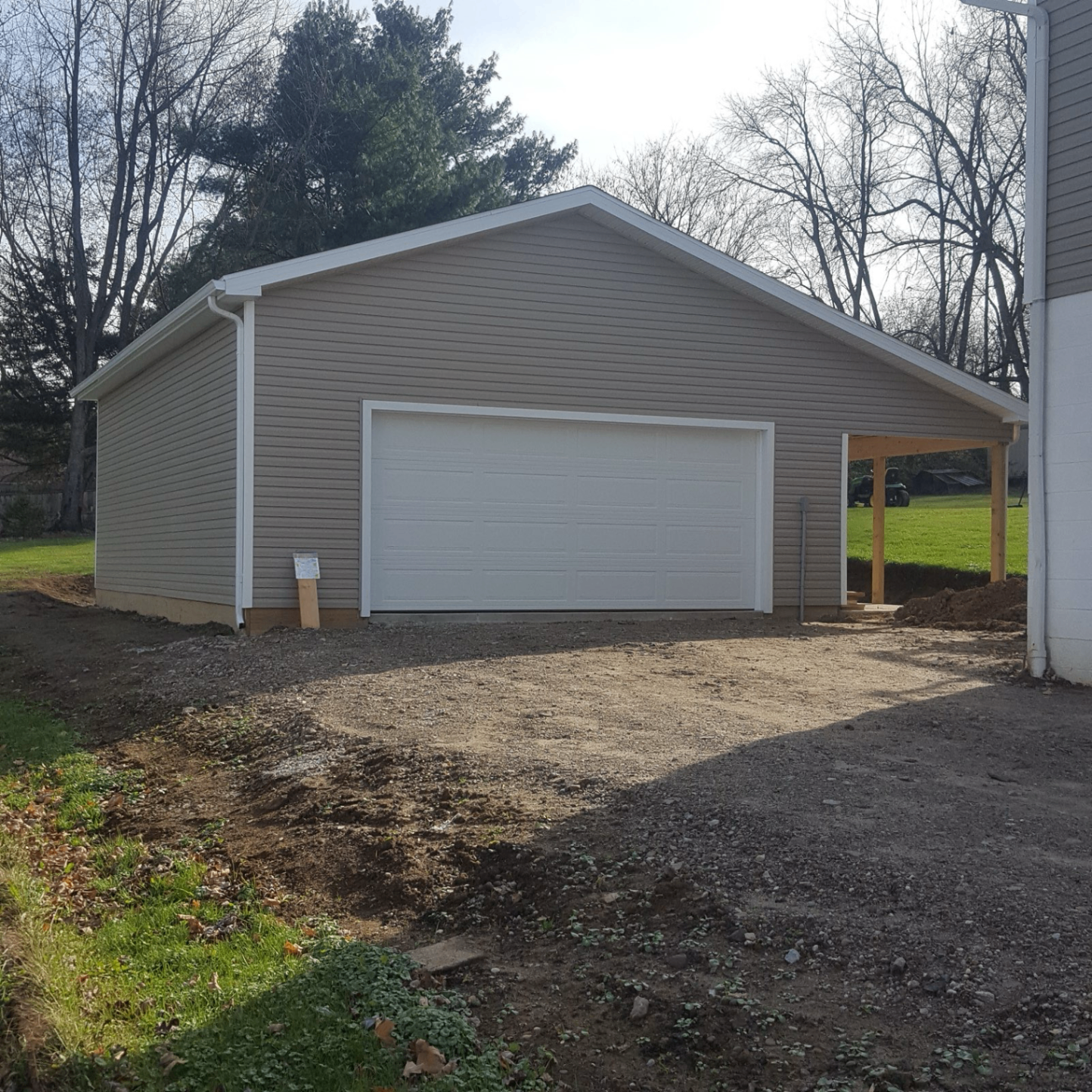 Completed detached garage with tan siding and white trim
