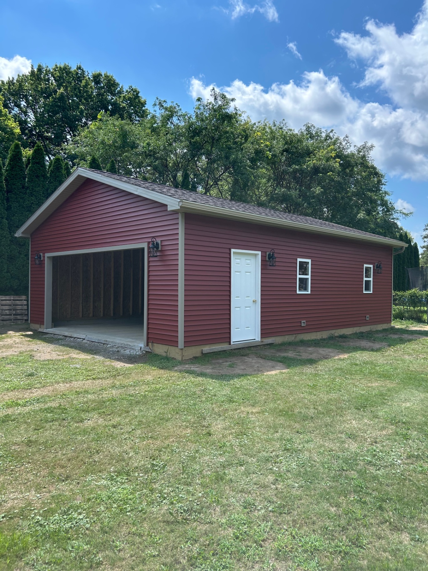 Completed red barndominium with garage bay built by Lou Reynolds Construction in Northeast Ohio