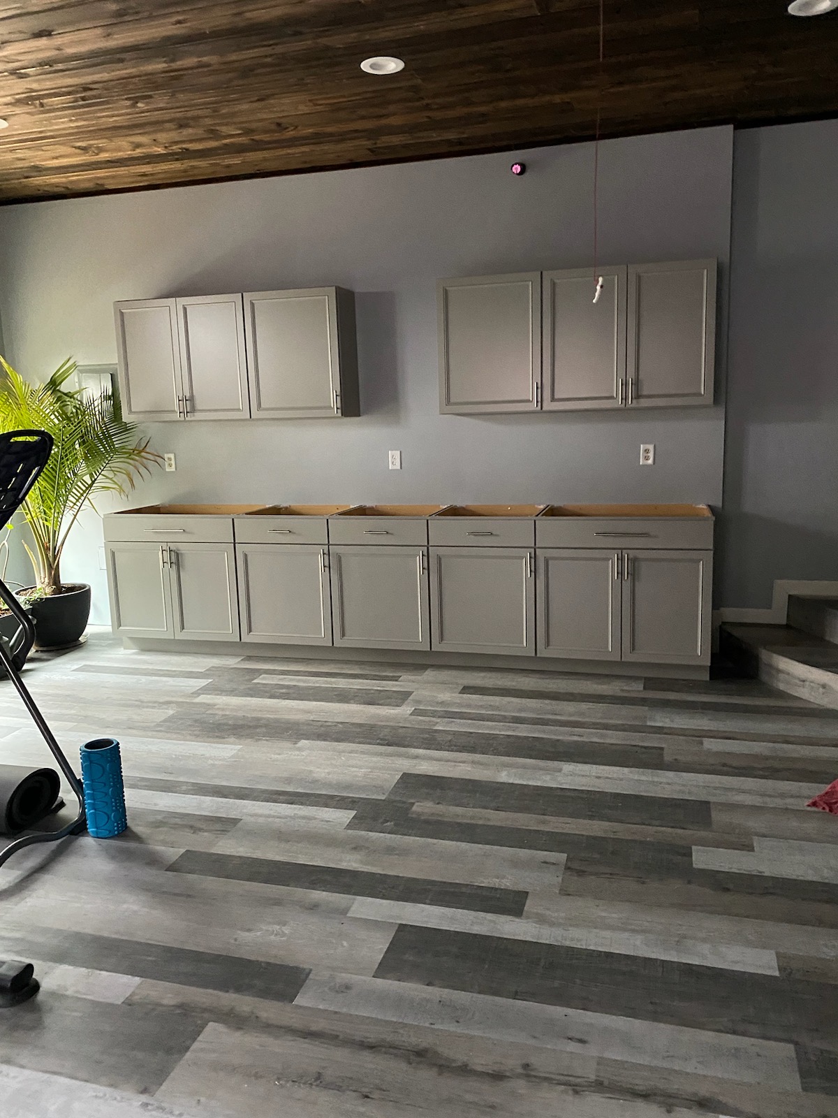 Home addition interior with new gray cabinetry, wood plank ceiling, and vinyl plank flooring