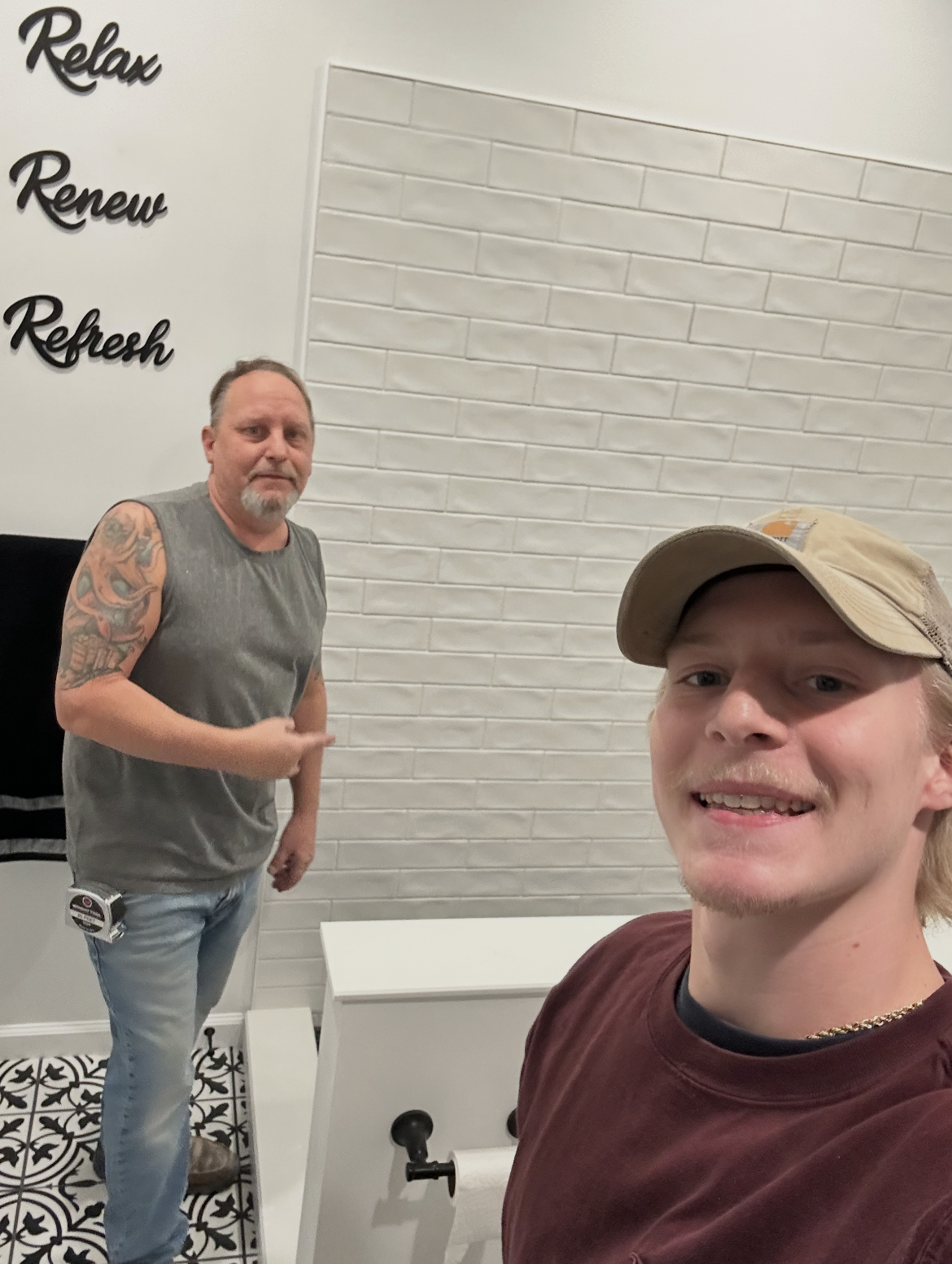 Lou Reynolds and his son Louie standing in a completed bathroom remodel