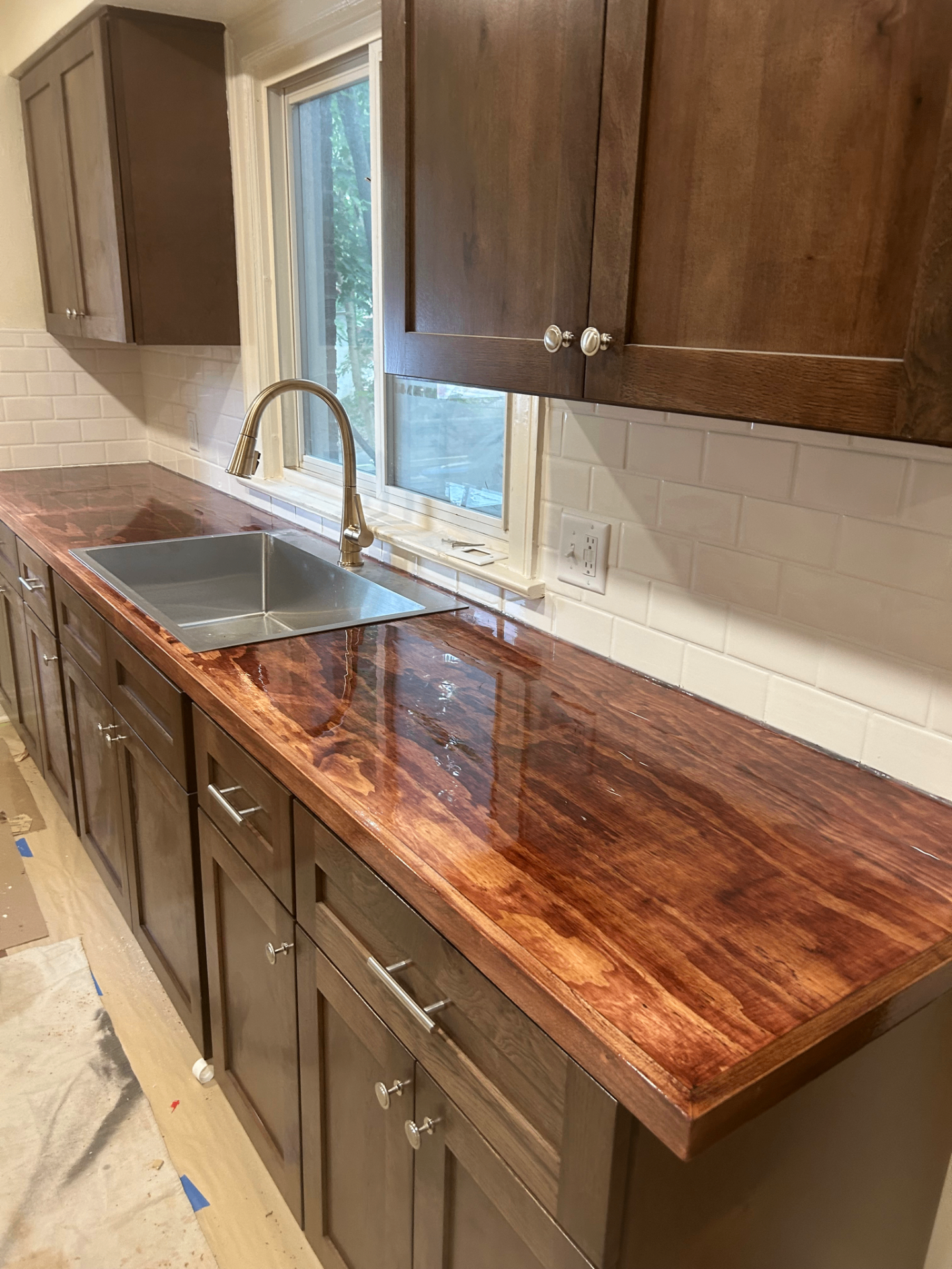 Kitchen remodel with dark wood cabinets, live-edge countertop, and subway tile backsplash